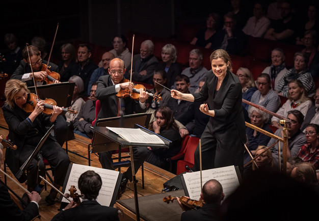 Kvinna som dirigerar. Fotografi.