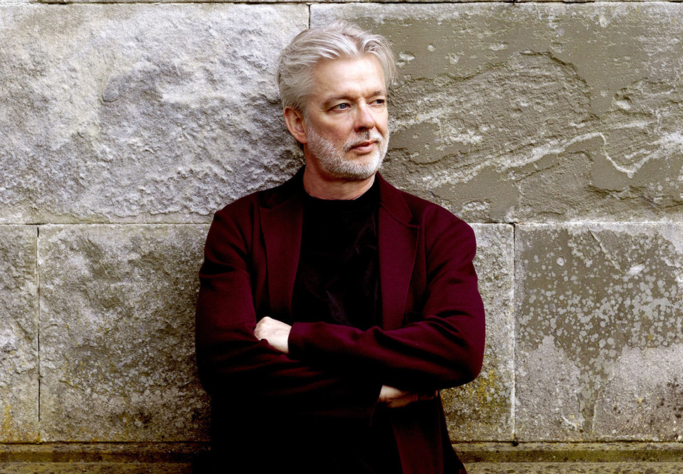 Man som lutar sig mot en stenvägg. Fotografi