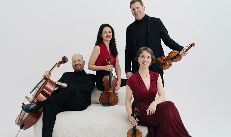 Fyra musiker som håller i sina instrument. Fotografi