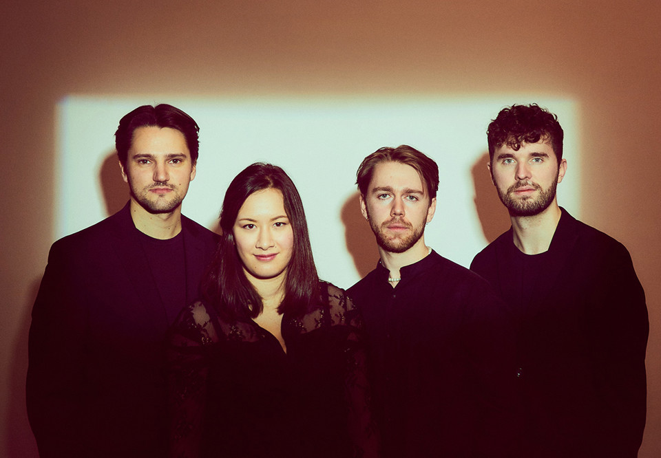 Fyra musiker på rad. Fotografi.