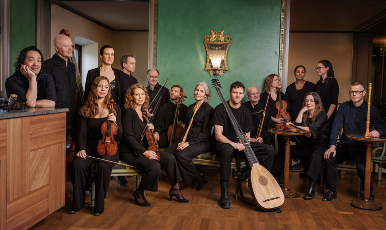 En stor grupp musiker tittar in i kameran. Fotografi.