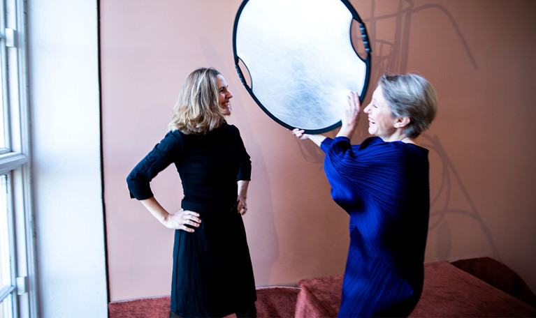 Två personer med en spegel mellan sig. Fotografi.