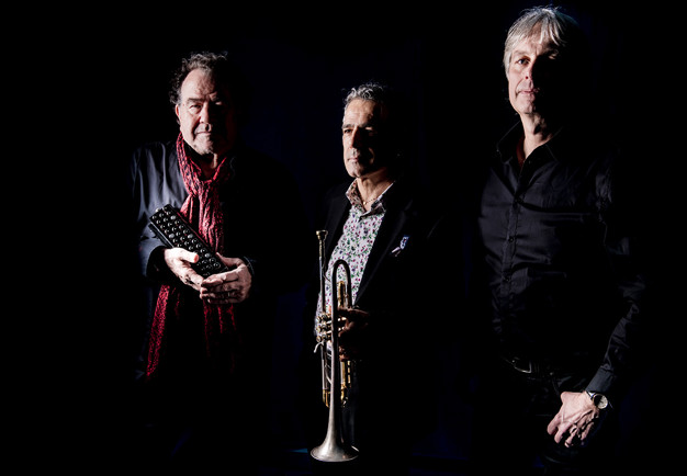 Tre män som går på rad