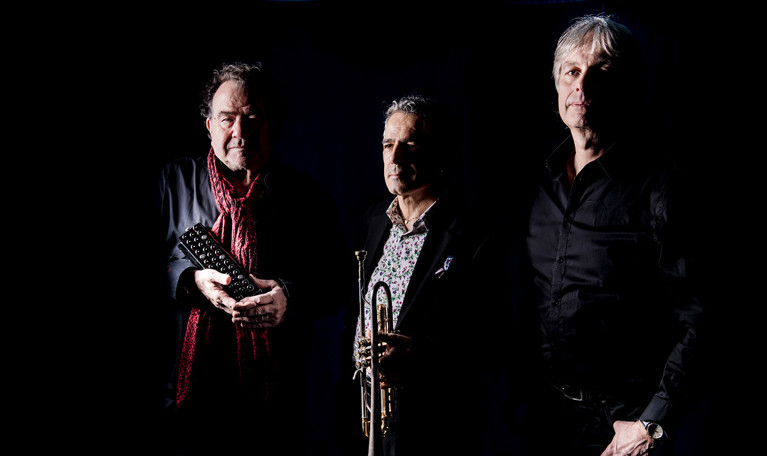 Tre män som går på rad