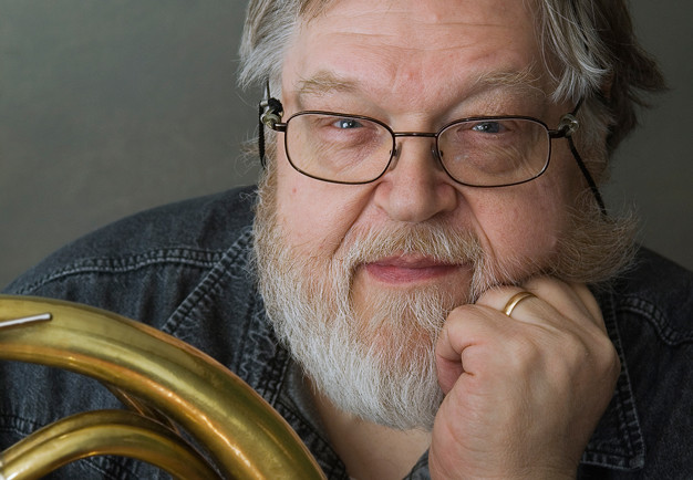 Man med horn i handen. Fotografi.