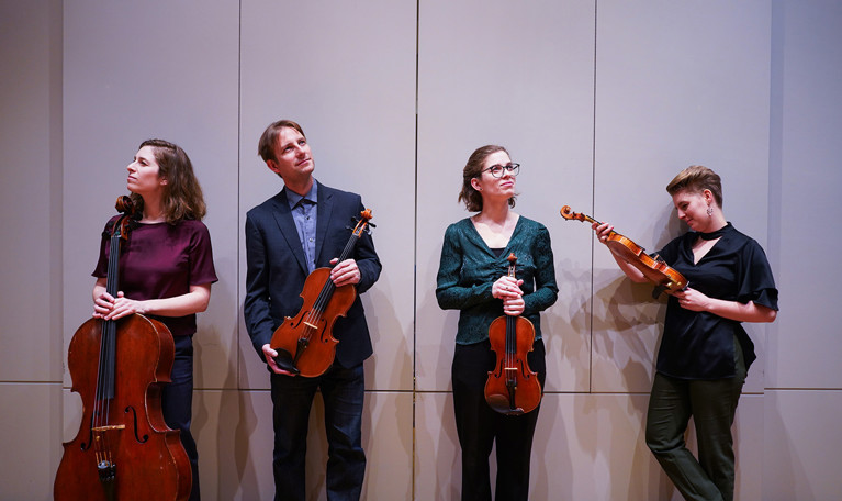 Fyra musiker med instrument. Fotografi.