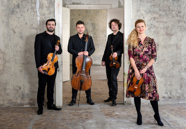 Fyra musiker på rad. Fotografi.