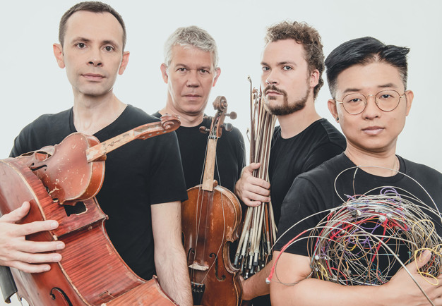 Fyra musiker med instrument. Fotografi.
