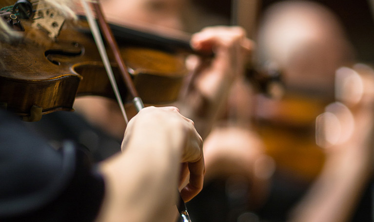 Närbild på fiol med stråke