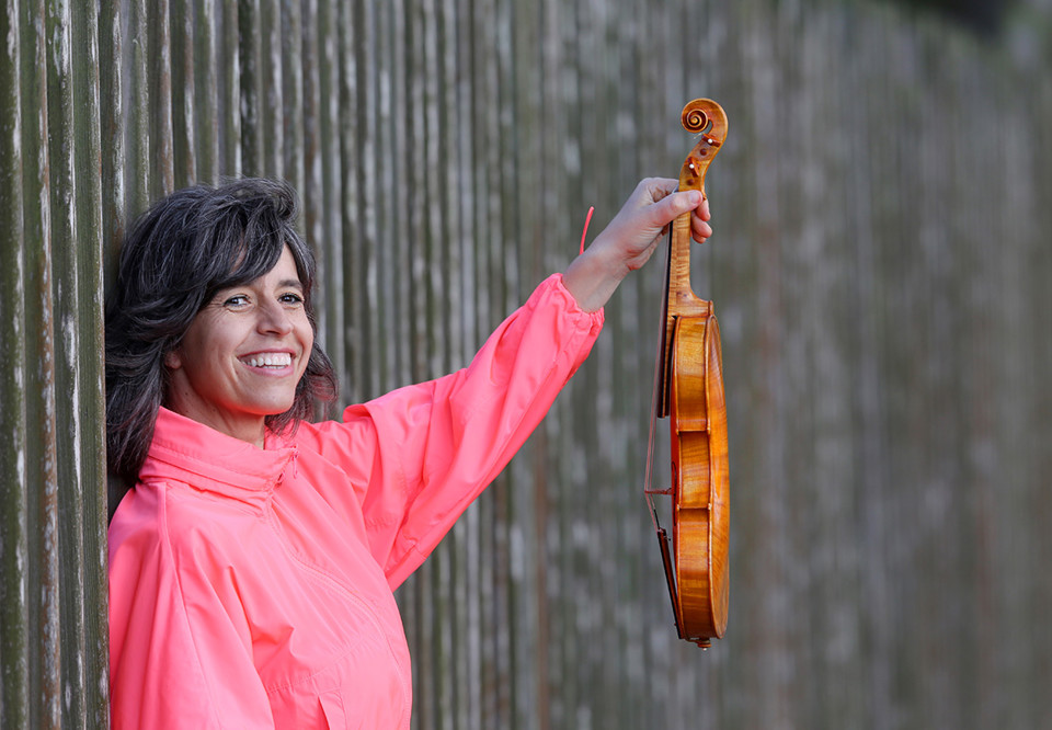 Kvinna som håller i en fiol. Fotografi.