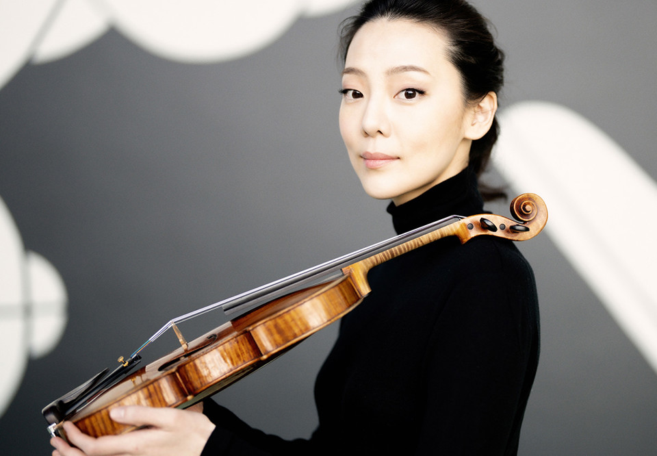 Kvinna som håller i en violin. Fotografi.