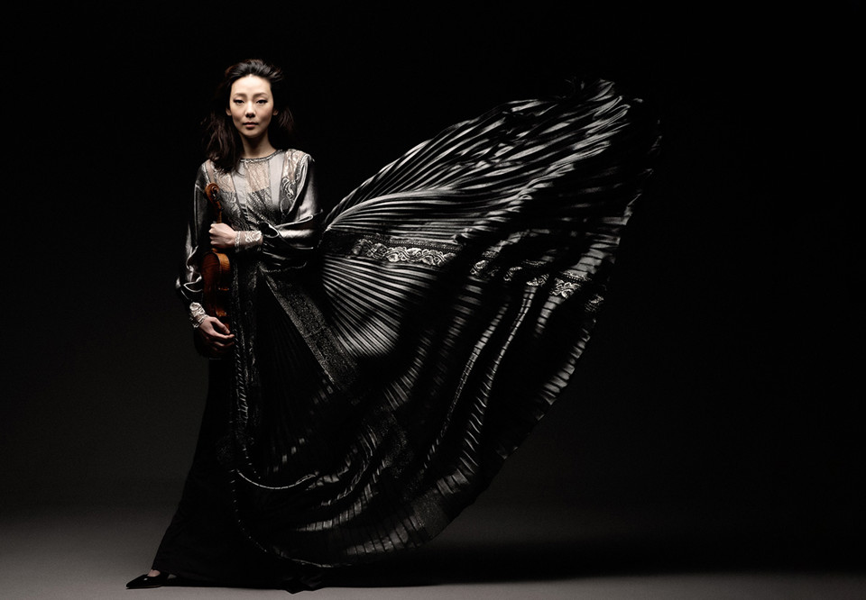 Man som sitter på en pianopall. Fotografi.