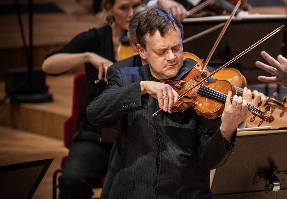 Man som spelar violin. Fotografi.