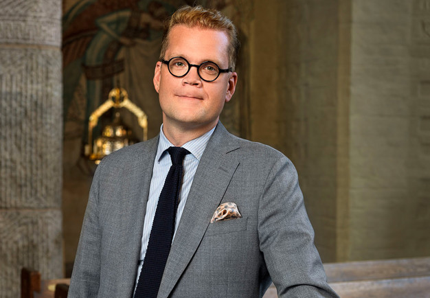 Man framför orgel. Fotografi.