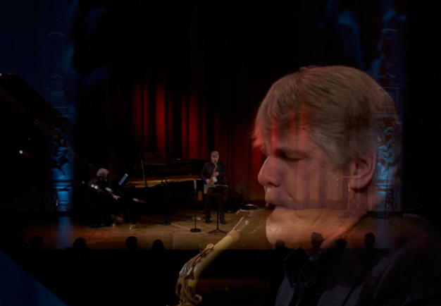 Man som spelar saxofon. Fotografi.