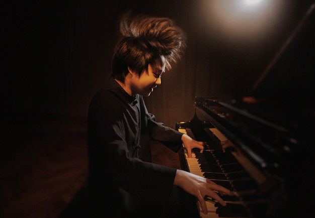 Ung kille som spelar piano. Fotografi. 