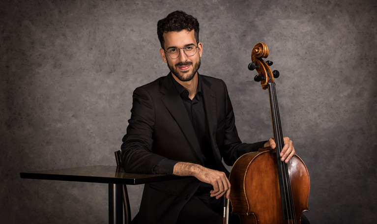 Porträttbild på en leende kvinna med cello. Fotografi.