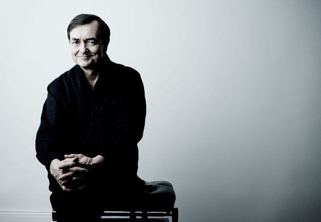 Man som sitter på en pianopall. Fotografi.