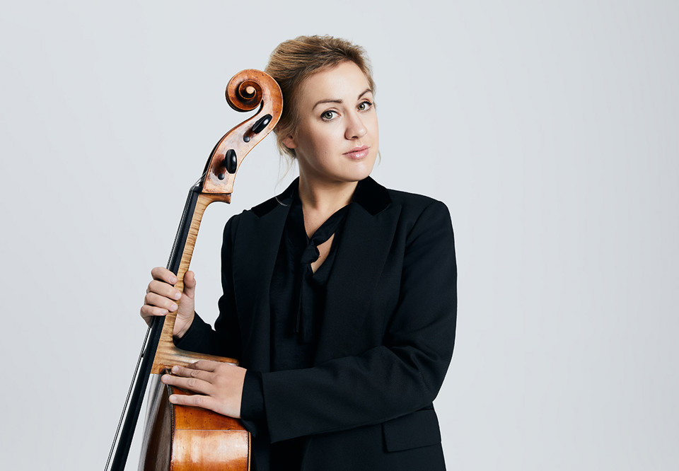 Kvinna som håller i en cello. Fotografi.