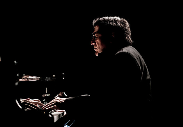 Man som spelar piano. Fotografi.