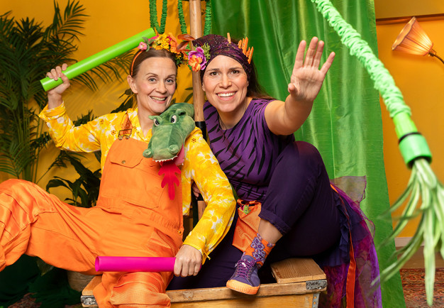 Två glada kvinnor i färgglada kläder. Fotografi.