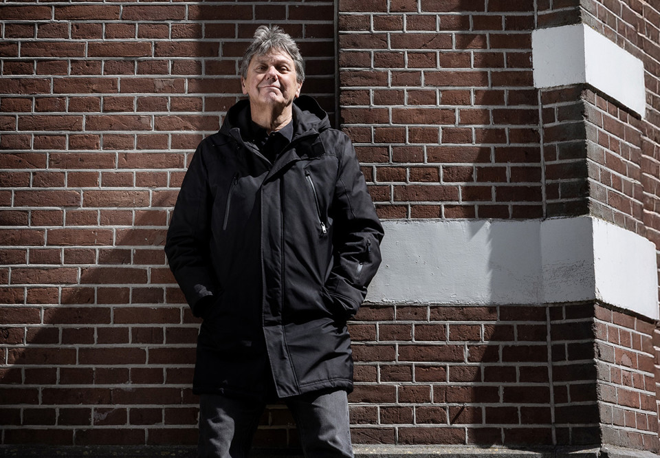 Man som sitter på en bänk. Fotografi.